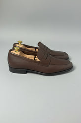 Dark brown leather slip-on loafers with classic design for casual and office wear.